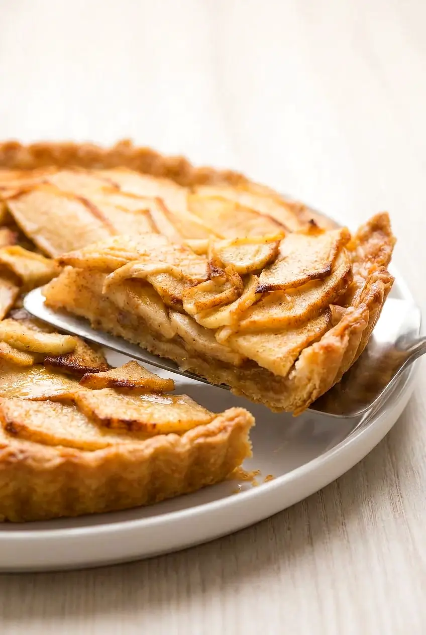 Close-up of a cut slice of air fryer apple tart showing the soft cinnamon apple filling and flaky crust.