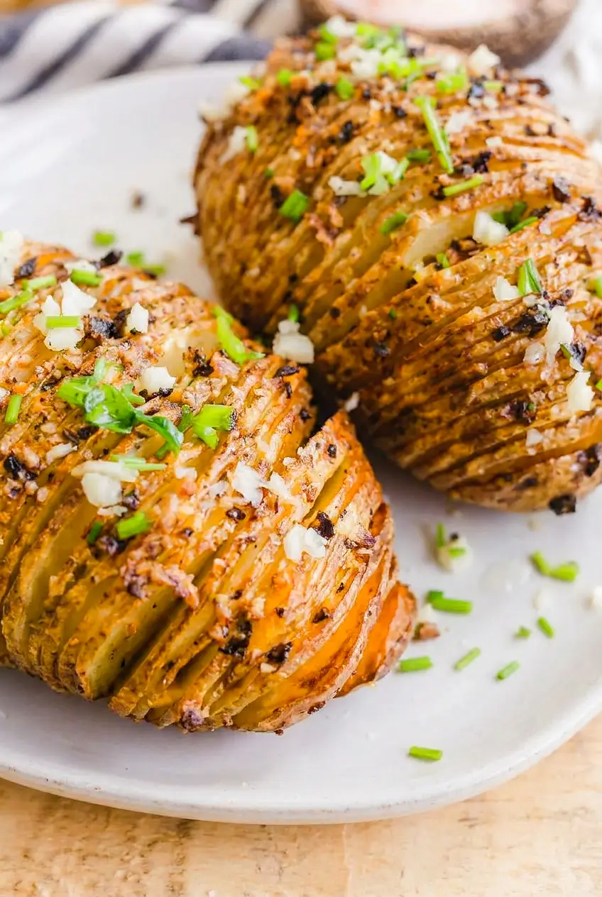 Close-up of air fryer hasselback potatoes showing crisp sliced edges and fluffy centers with chives