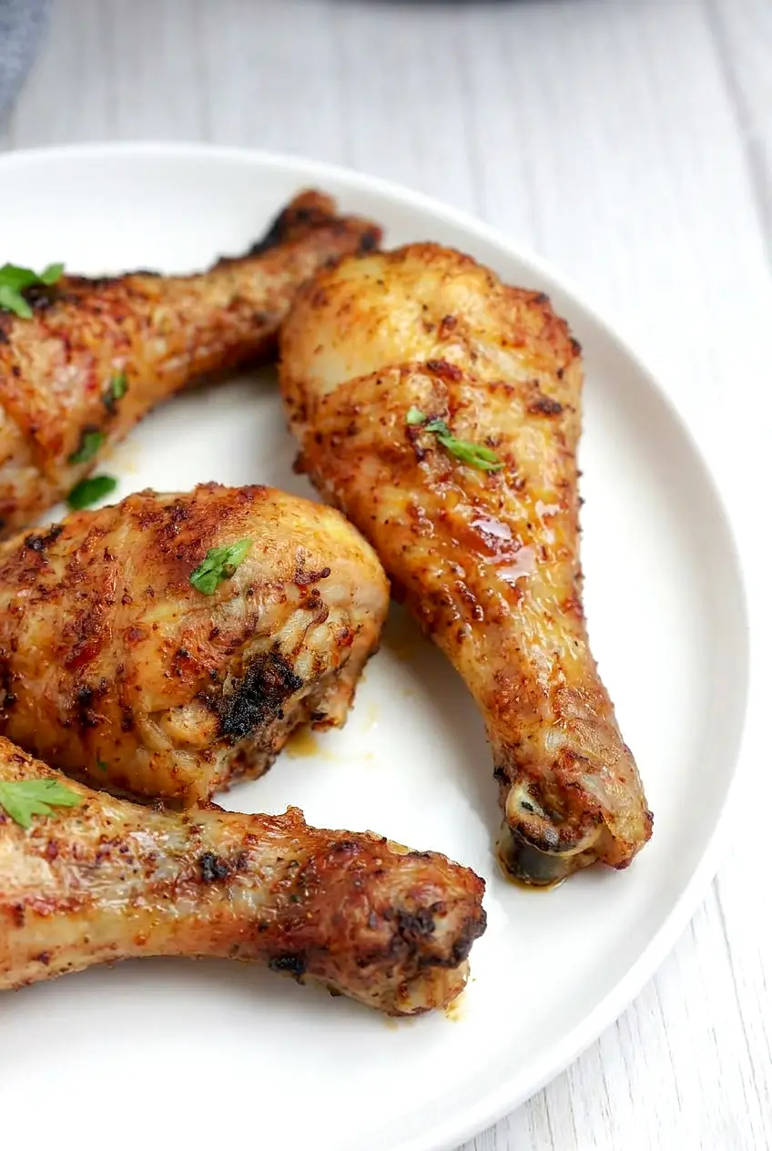 Close-up of air fryer frozen chicken drumsticks with crisp browned skin and juicy meat near the bone