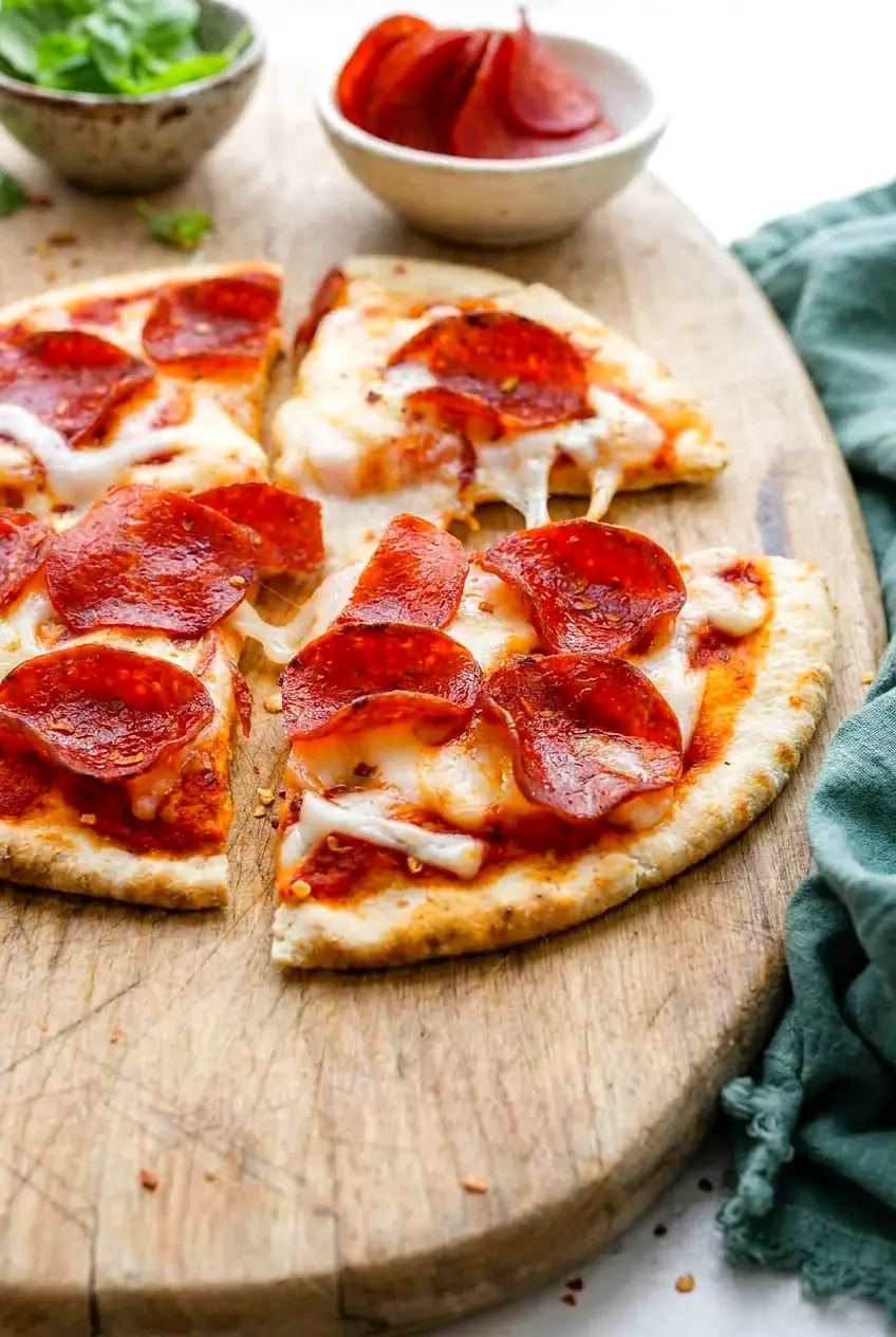 Close-up of air fryer pita pizza slices showing the crisp crust, melted cheese, and pepperoni.