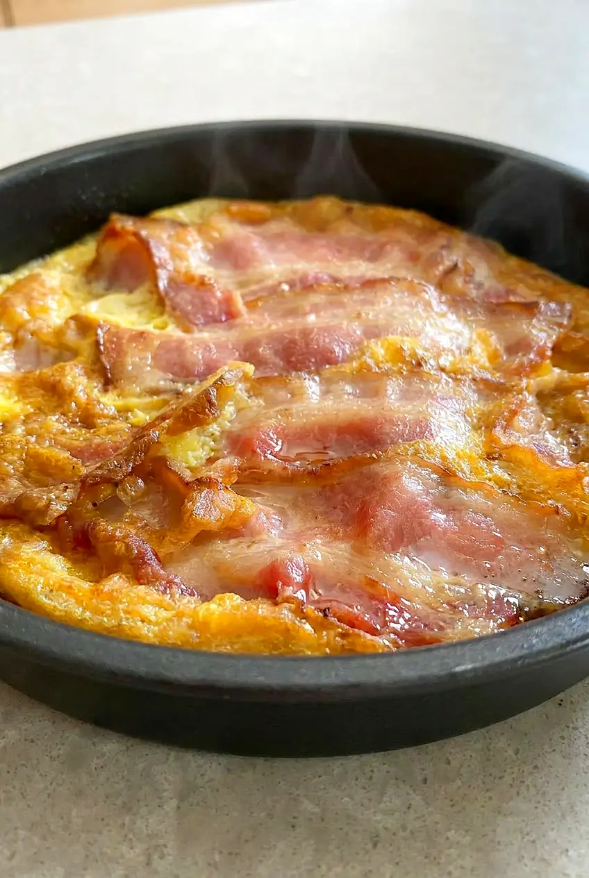 Close-up of air fryer bacon and eggs with crisp browned bacon and softly set eggs