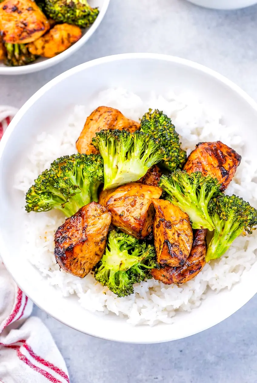Air fryer chicken bites and broccoli served over rice with parsley garnish
