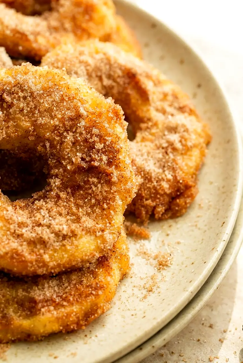 Close-up of air fryer crispy cinnamon apple rings showing the golden crust and tender apple center