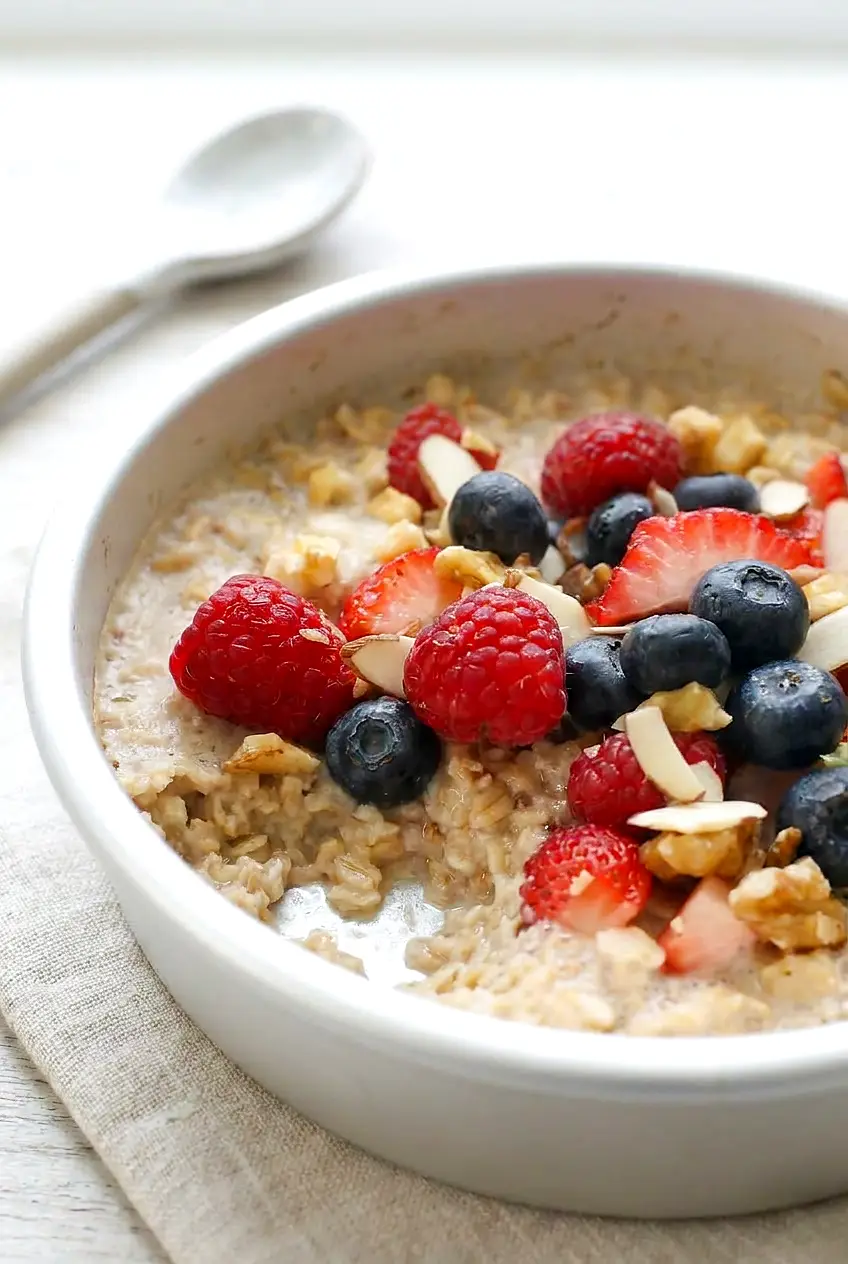 Close-up of air fryer oatmeal with berries showing the creamy baked texture in a white metal pan