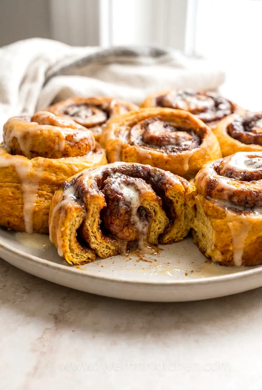 Close-up of air fryer pumpkin pie cinnamon rolls showing the soft spiral layers and gooey cinnamon filling