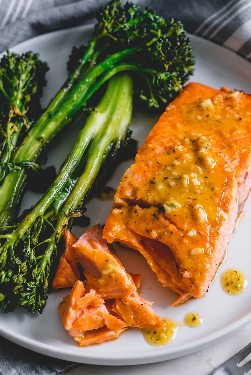 Overhead view of flaky garlic-seasoned air fryer salmon served with roasted broccolini.