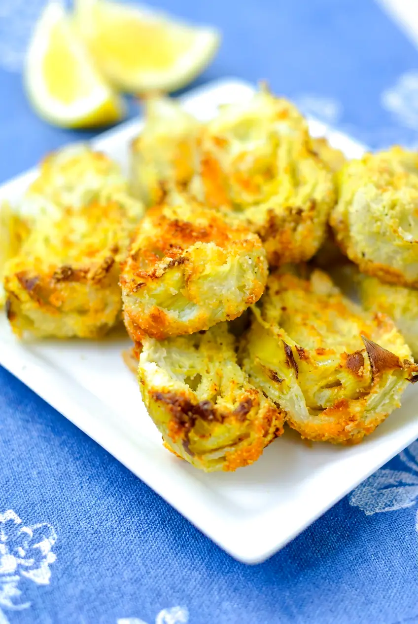 Close-up of air fryer artichoke hearts showing crisp golden edges and crunchy almond flour-Parmesan coating